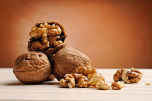 group of walnuts on a white wooden table with brown background