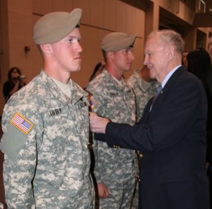 Retired Col. Ralph Puckett places the hard-earned 75th Ranger Regiment scroll on Pfc. Nathan Lively at the Ranger Assessment and Selection 1 graduation, March 5. (Photo provided by 75th Ranger Regiment Public Affairs)
