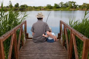 father with little son fish on the shore of Lake