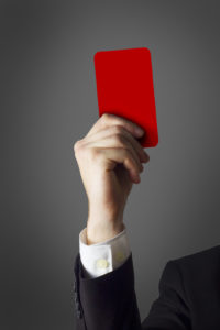 hand of a businessman holding a red card in the air
