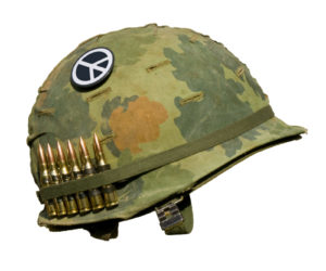 A US military helmet with an M1 Mitchell pattern camouflage cover from the Vietnam war, with six rounds of 7.62mm ammunition and a peace symbol button.