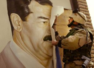 In Safwan, Iraq, U.S. Marine Major Bull Gurfein pulls down a poster of Iraqi President Saddam Hussein on March 21, 2003. Chaos reigned in southern Iraq as coalition troops continued their offensive to remove Iraq's leader from power.