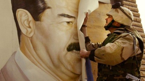 In Safwan, Iraq, U.S. Marine Major Bull Gurfein pulls down a poster of Iraqi President Saddam Hussein on March 21, 2003. Chaos reigned in southern Iraq as coalition troops continued their offensive to remove Iraq's leader from power.