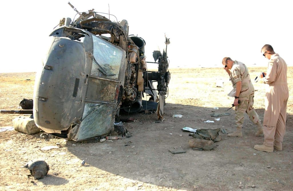 Local safety officials inspect the wreckage of an Army UH-60 Blackhawk crash at Tallil Air Base, Iraq. All four soldiers on board were rescued from the helicopter by members of Tallil's 407th Air Expeditionary Group and 407th Expeditionary Medical Squadron, on Sept. 21, 2004. (Airman 1st Class Jeff Andrejcik/USAF photo)